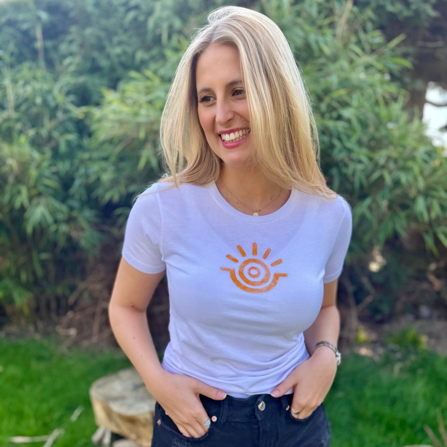 Model smiling wearing positive slogan tee with yellow sunshine emblem
