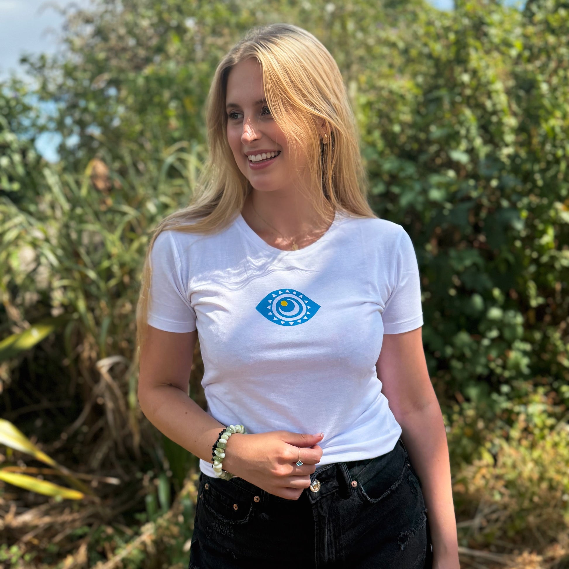 Woman wearing a white t-shirt with a blue eye design outdoors